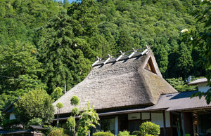 山あいに建つ茅葺き屋根の家。京都府美山町（イメージ）